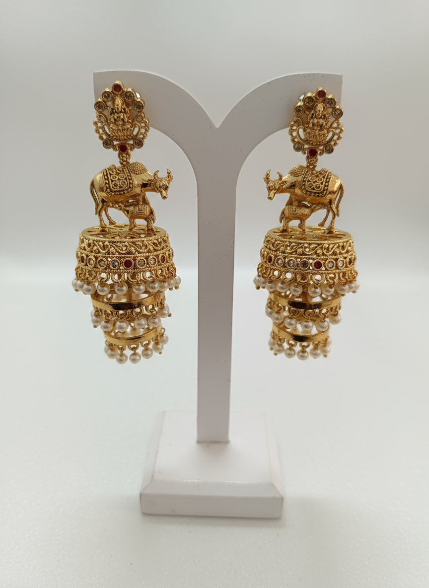 Gold jhumka earrings on display stand