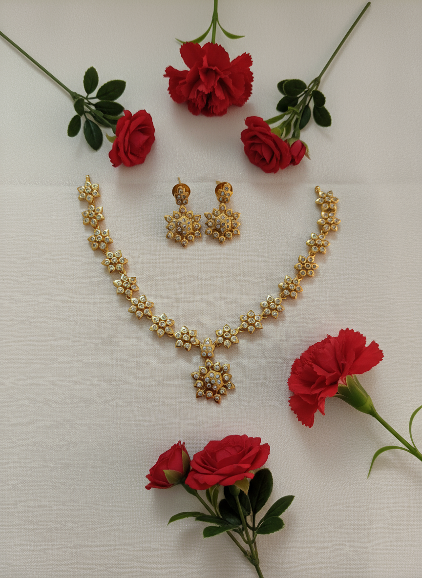 Gold necklace set on white satin with red flowers